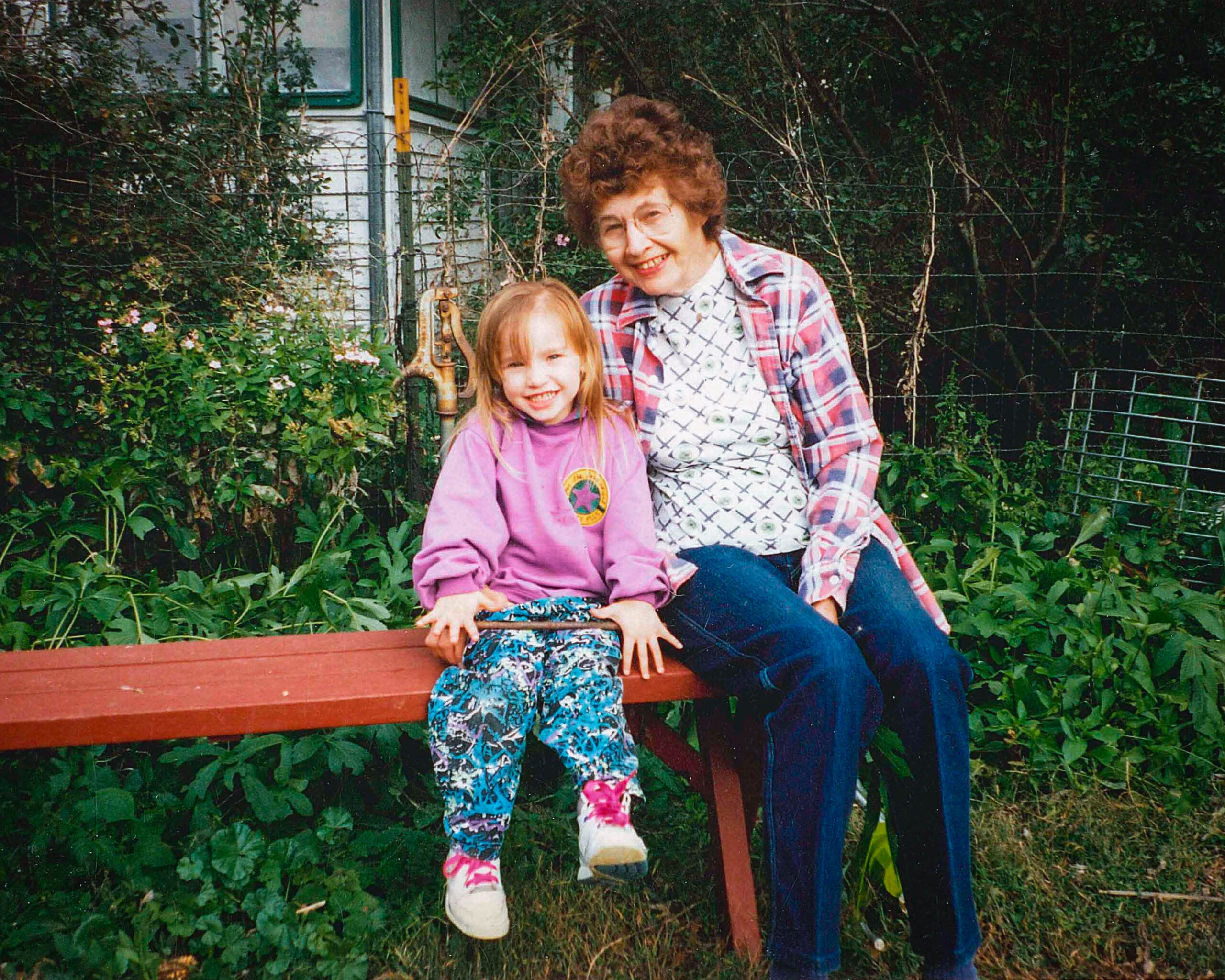 Leona Ihde poses with a child in her Beaver Crossing garden.