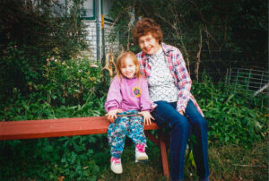 Leona Ihde poses with a child in her garden in Beaver Crossing.
